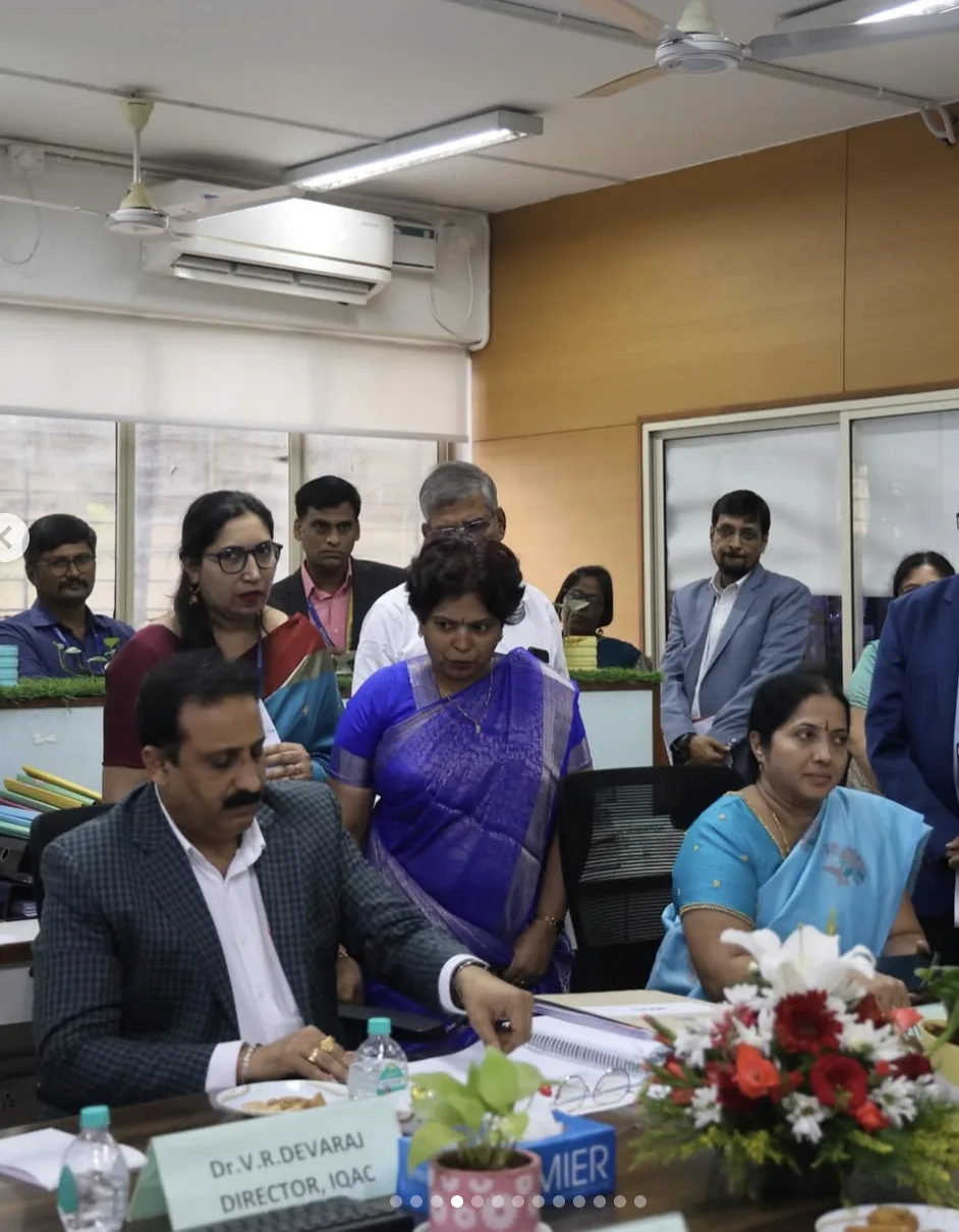 Faculty and guests in discussion at a college meeting